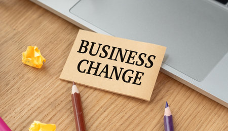 Business Change sign is on a desk with a pair of pencils and some crumpled paperの写真素材