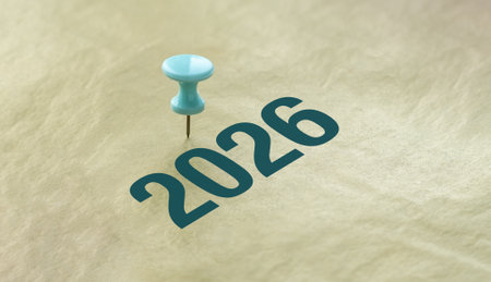 A blue pin is stuck into a piece of paper with the number 2026 written below it. Concept of...