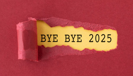 A torn piece of paper with the words Bye Bye 2025 written in black on a red backgroundの写真素材