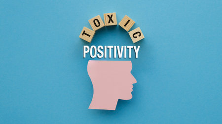 A head with the word Toxic Positivity written above it. The head is surrounded by wooden blocks. Concept of positivity and the importance of avoiding toxic situationsの写真素材