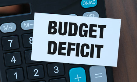 Budget Deficit Note on Calculator with American Flag: National Debt, Fiscal Policy, and Economyの写真素材