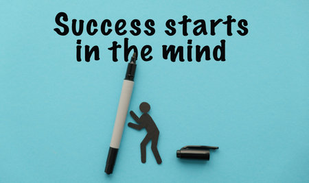 Success Starts in the Mind motivational text with a small human figure and a marker on a blue...