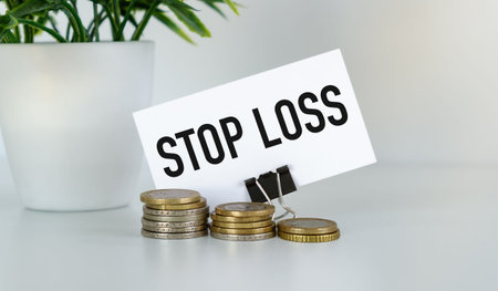 STOP LOSS message on card with euro coins for stock market trading tutorials, financial risk...