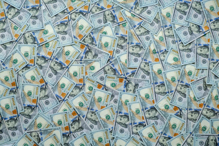 Scattered bills cover the entire frame. Fifty-dollar notes lie in chaotic, overlapping piles. No people appear in the image. The scene suggests sudden abundance or financial gain
