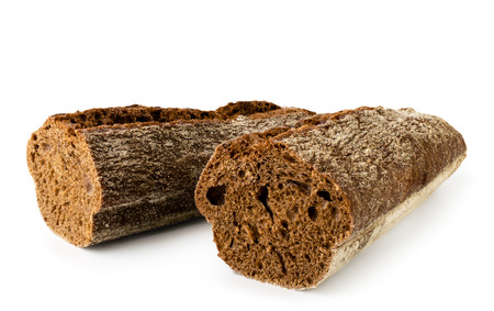 Two halves of a black loaf of bread close-up on a white background.
