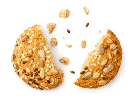 Oatmeal cookies with seeds broken in half on a white, isolated. The view of the top.の写真素材
