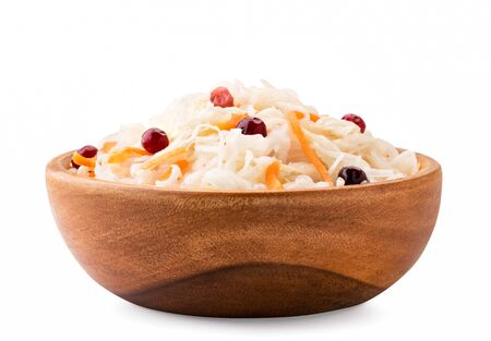 Sauerkraut with carrots and cranberries in a wooden plate on a white background, isolated.の写真素材