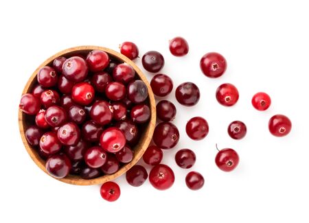 Cranberries in a wooden plate and scattered on a white background. The view of top.の写真素材