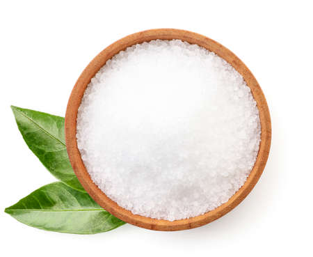 Citric acid in a plate and green leaves close up on a white background, isolated. The view from topの写真素材