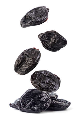Prunes falling on a heap close-up on a white background. Isolated dried plumの写真素材