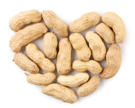 Peanuts not peeled in the shell in the shape of a heart close-up on a white background, isolated....
