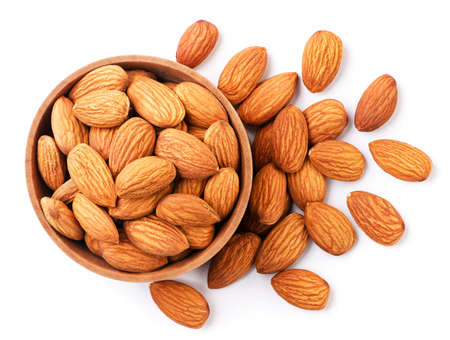 Peeled almonds in a wooden plate close-up on a white background, isolated. Top viewの写真素材