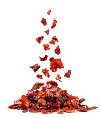Dried ground red pepper falls on a pile close-up on a white background. isolatedの写真素材