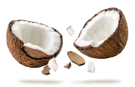 Coconut broken into two halves flies on a white background. Isolatedの写真素材