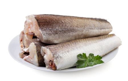 Hake fish carcasses with leaves in a plate close-up on a white background. Isolatedの写真素材