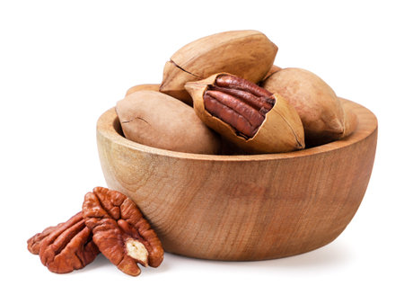 Pecans in a wooden plate close-up on a white background. Isolated