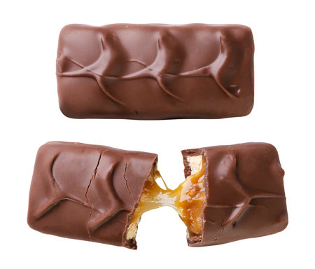 Chocolate bar with caramel and broken in half close-up on a white background. Top view.の写真素材