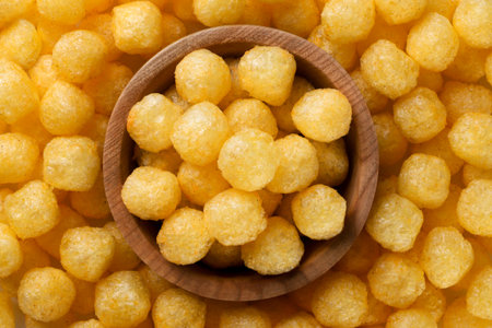 Corn balls in a wooden plate close-up, background. Top view
