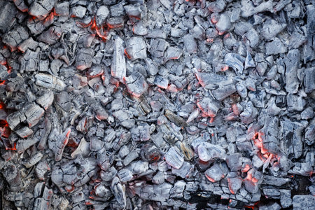Burning coals close-up, background. Smoldering charcoal top view