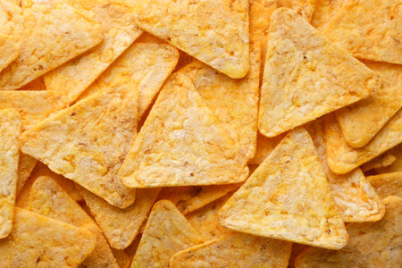 Triangular corn chips close-up, background. Top view