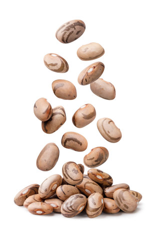 Raw beans falling on a pile close-up on a white background. Isolatedの写真素材