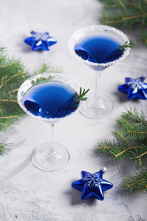 Christmas composition with martini drinks with rosemary and sugar decoration, fir-trees, stars, 


in blue colors, gray concrete background. Winter holiday, New Year party concept.の写真素材