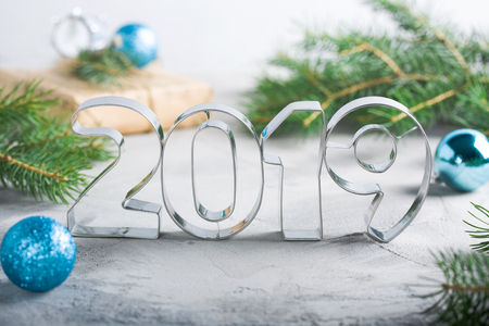 Happy New Year 2019 composition with metallic letters, balls, fir-tree, craft gift box in blue 


colors, gray concrete background. Greeting card.の写真素材