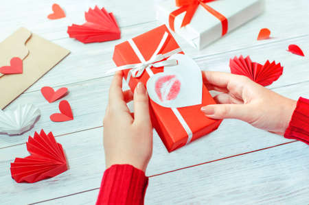 a girl holds a Valentines Day gift with a message and paper hearts aroundの写真素材