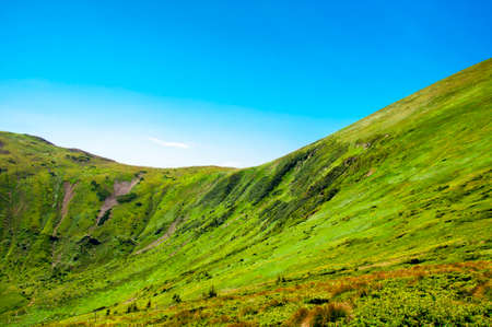 beautiful, summer slopes of mountains covered with green young grass against the blue sky, travelの写真素材