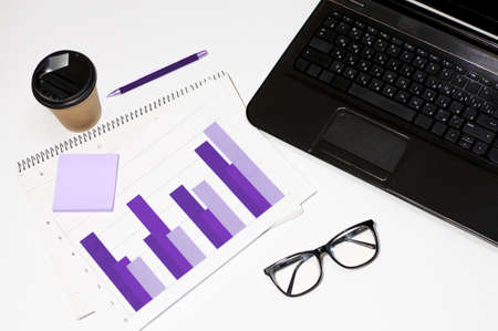 workplace in the office or at home, laptop with graphs on a white backgroundの写真素材