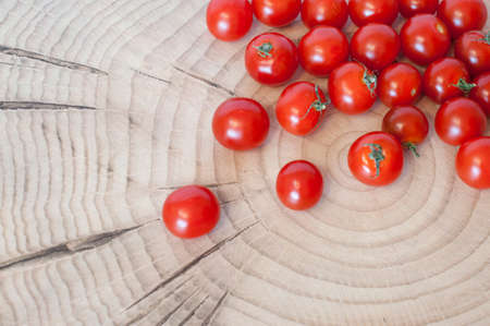 fresh cherry tomatoes scattered on a wooden deckの写真素材