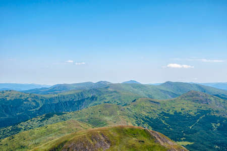 beautiful, summer slopes of mountains covered with green young grass against the blue sky, travelの写真素材