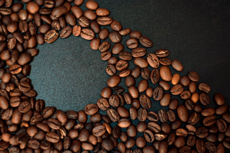 roasted coffee beans on a black wooden tableの写真素材