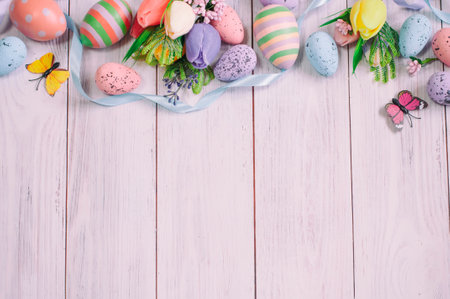 Easter background, on a light tree spring flowers, Easter eggs and ribbons, top view, space for text