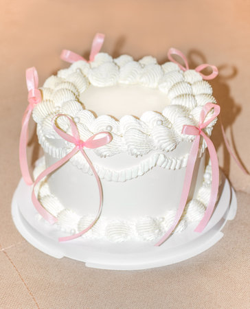 vintage cake with pink bows of delicate cream colorの写真素材