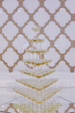 Pyramid of wine glasses with champagne on a buffet table.の写真素材