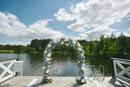 Wedding arch with fresh flowers on the pier - wedding decoration.の写真素材