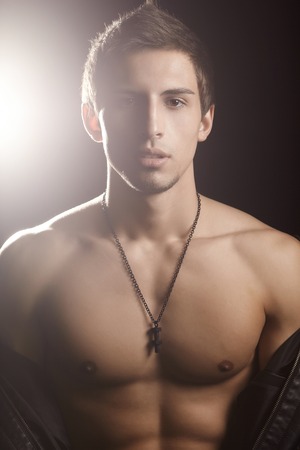 Shirtless, fitness shaped muscular handsome men with perfect strong body posing at black background.