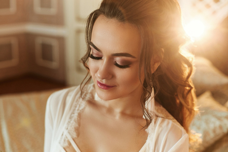 Beautiful brunette model girl with perfect bright makeup in fashionable lace lingerie smiling and posing with closed eyes at vintage interiorの写真素材