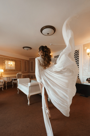 Sexy brunette model girl with perfect body and with wedding hairstyle in fashionable lingerie and in stylish peignoir at luxury vintage interiorの写真素材