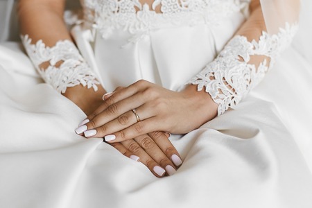 Beautiful female hands with the wedding ring and elegant manicureの写真素材