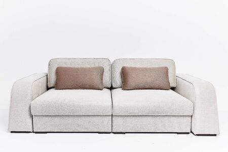 The beige couch in modern style with two brown pillows isolated on white backgroundの写真素材