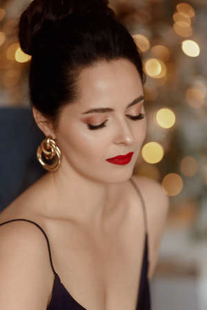 Portrait of a young woman with modish hairstyle and bright makeup ready for the New years partyの写真素材