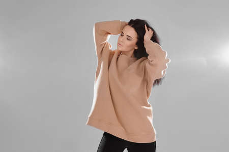 Charming young woman with perfect trendy makeup wearing a stylish sweatshirt over white backgroundの写真素材