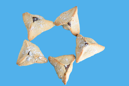 Purim holiday celebration. Top view, flat lay, mockup - Image.Hamantaschen cookies isolated on blue background.の写真素材