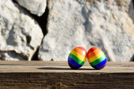 Lgbt couple family. Two eggs with rainbow lgbt flag color on nature outdoor background. Creative idea for illustration gay parade,LGBTQ travel, party, homosexual marriage, valentines day, Easter.の写真素材