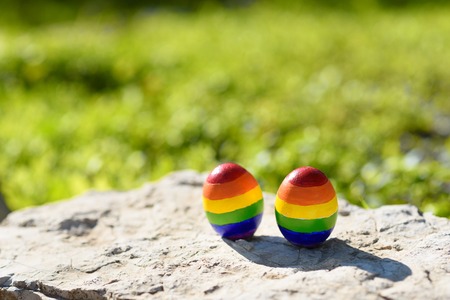 Gay getaways. Two eggs with rainbow lgbt flag color. Happy homosexual couple. Weekend, tourism,...
