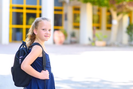 Portrair Happy smiling kid Back to school. Child little freckles girl with bag go to elementary school. Child of primary school. Pupil go study with backpack.の写真素材