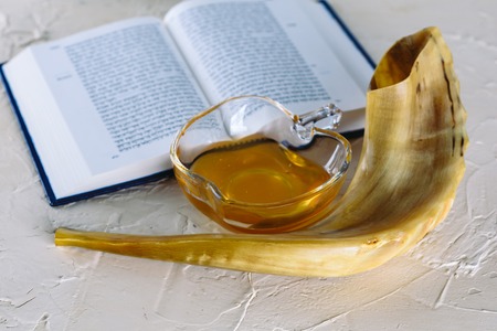 Rosh Ha Shana - Jewish new year composition of an red apple, Torah and Shofar horn for Rosh Hashanah on white modern putty background.の写真素材