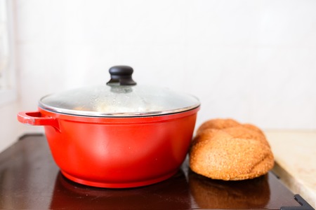 Hot plate for the Sabbath. Pot with traditional food and challah-special bread in Jewish cuisine....